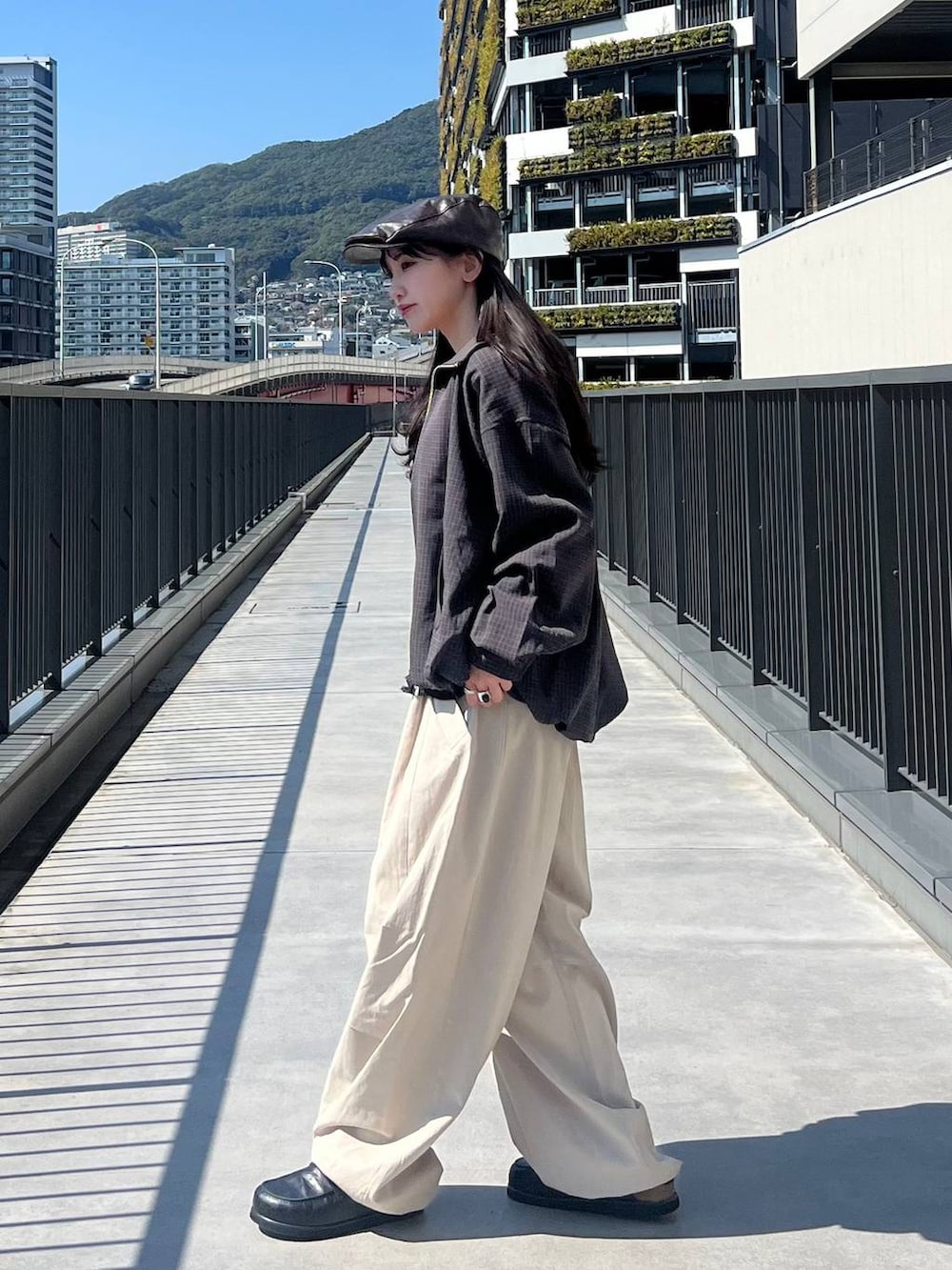 ブラック系のローファー、ブルー系のブルゾン、ブラック系のカーディガン/ボレロを着用したレディースの春コーディネートの2枚目の写真