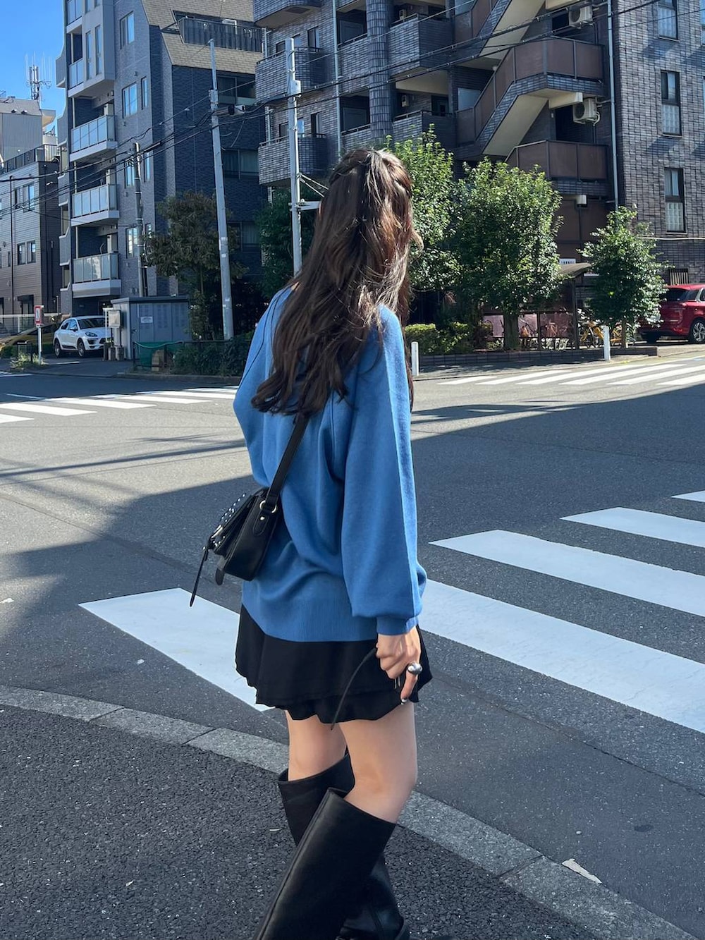 ブラック系のその他パンツ、ブラック系のショルダーバッグ、ブルー系のニット/セーターを着用したレディースの秋コーディネートの5枚目の写真