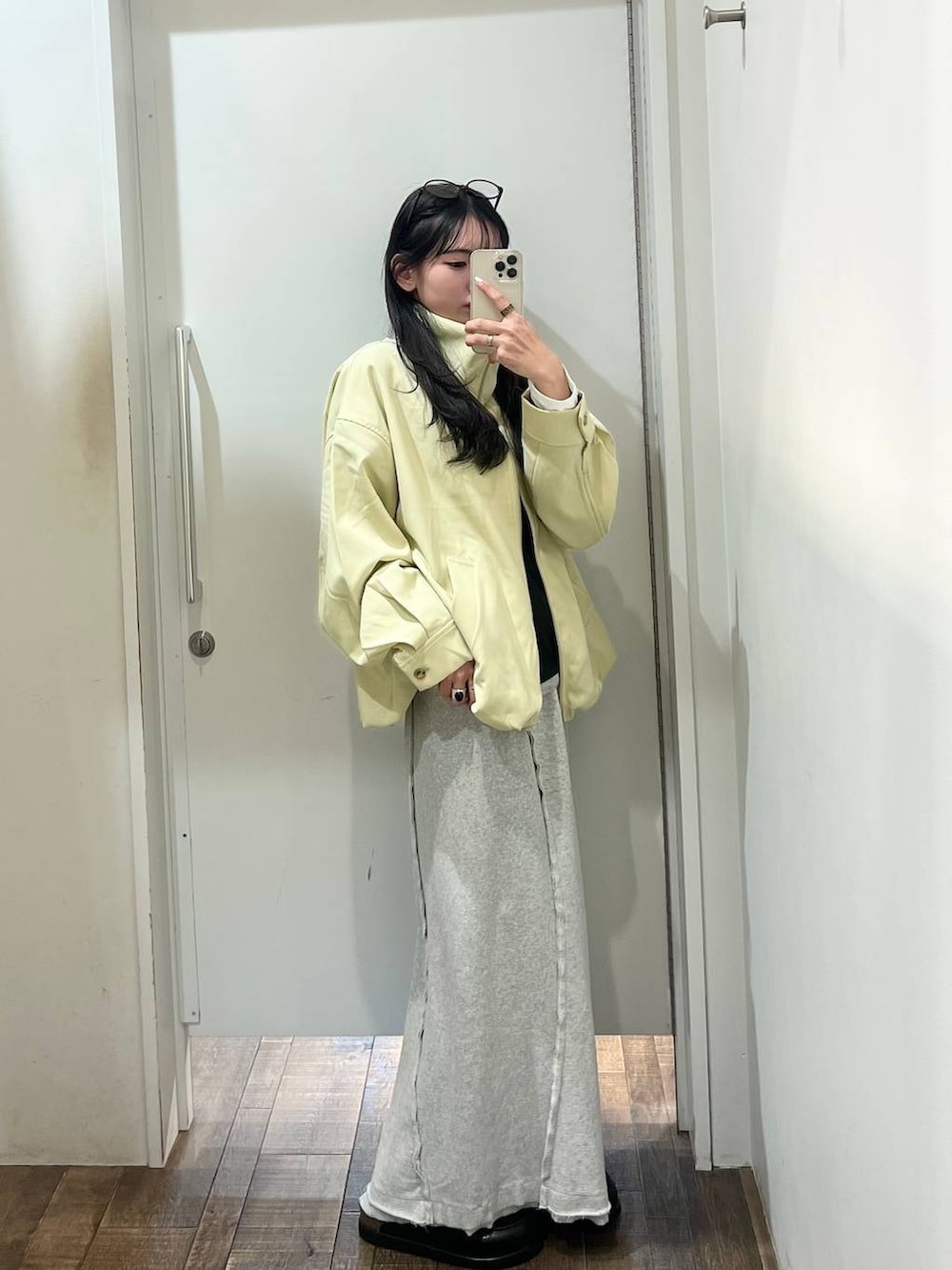 ブラック系のローファー、イエロー系のブルゾン、グレー系のスカートを着用したレディースの春コーディネートの5枚目の写真