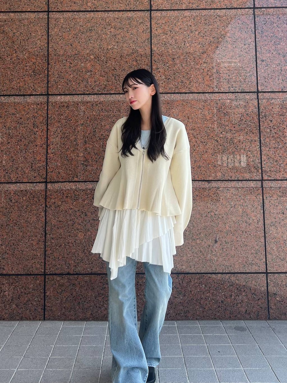 ブルー系のデニムパンツ、ブラック系のモカシン/デッキシューズ、ホワイト系のカーディガン/ボレロを着用したレディースの春コーディネートの2枚目の写真