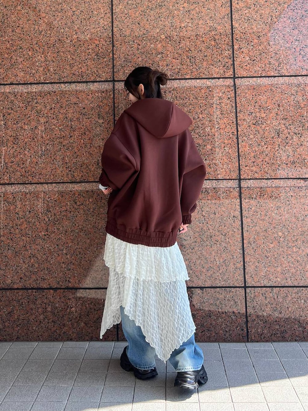 ブラウン系のパーカー、ブラウン系のローファー、ブルー系のデニムパンツを着用したレディースの秋コーディネートの7枚目の写真