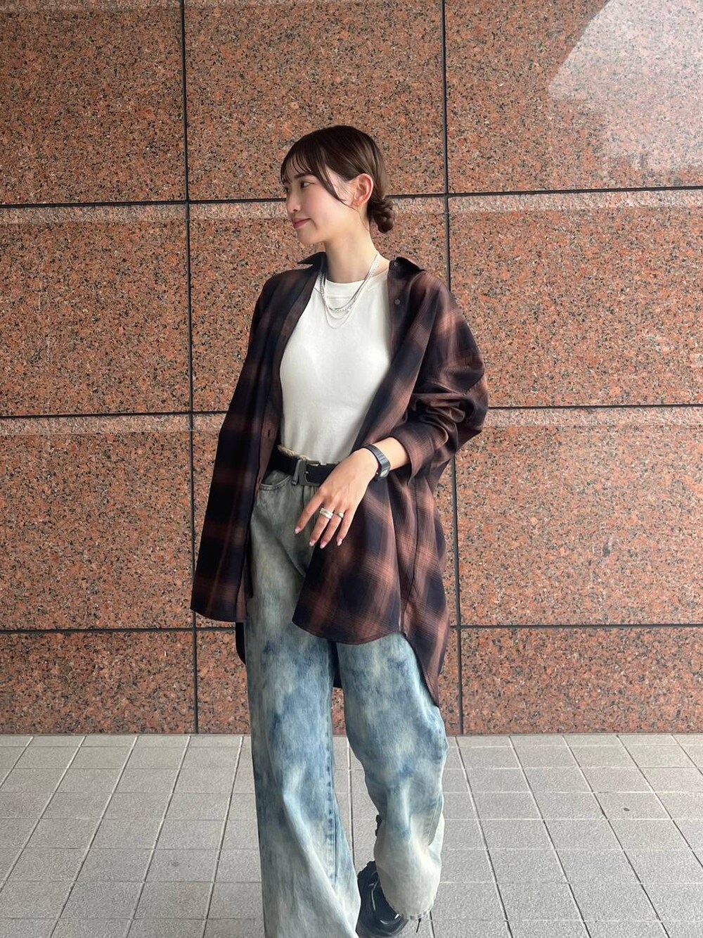 ブラウン系のシャツ/ブラウス、ブラック系のスニーカー、ブルー系のデニムパンツを着用したレディースの夏コーディネートの2枚目の写真