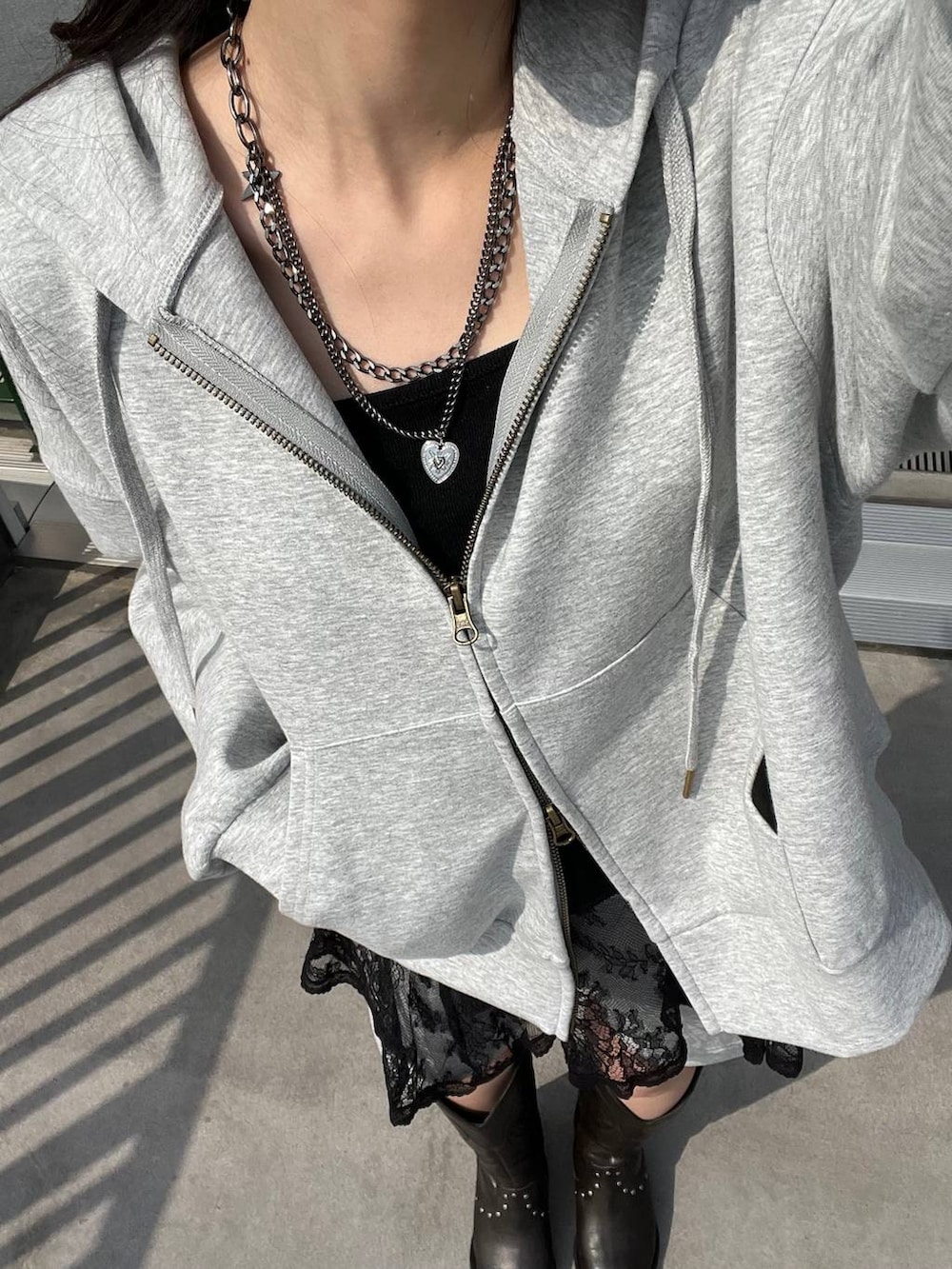 ブラック系のブーツ、グレー系のスウェットパンツ、グレー系のパーカーを着用したレディースの春コーディネートの6枚目の写真