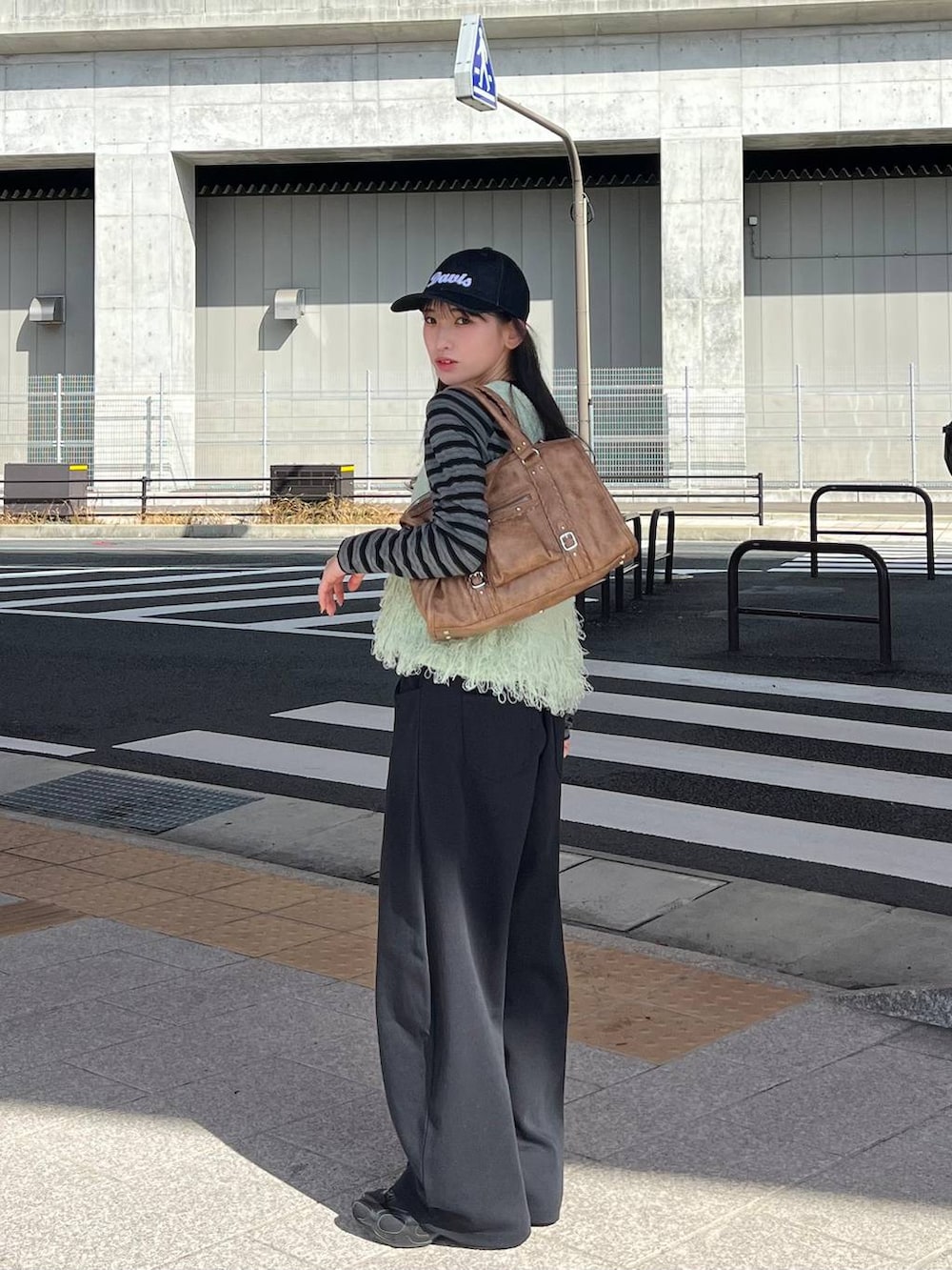 ブラック系のTシャツ/カットソー、ブラック系のスウェットパンツ、ブラウン系のボストンバッグを着用したレディースの冬コーディネートの7枚目の写真