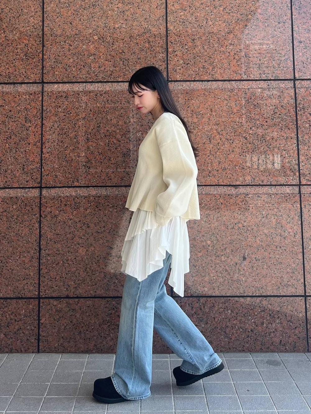 ブルー系のデニムパンツ、ブラック系のモカシン/デッキシューズ、ホワイト系のカーディガン/ボレロを着用したレディースの春コーディネートの4枚目の写真