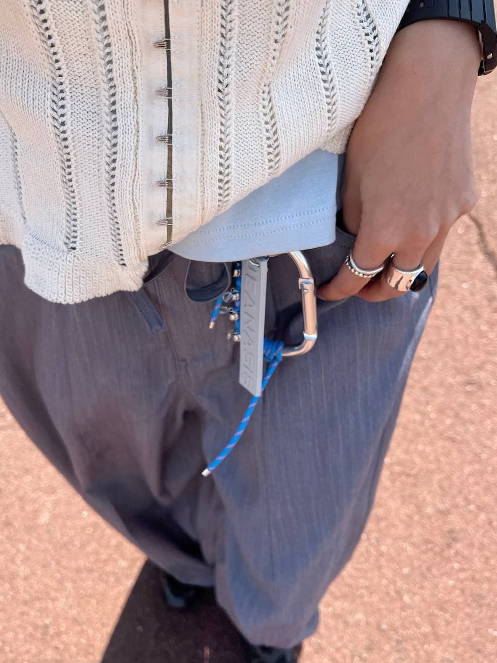 ブラック系のボストンバッグ、ベージュ系のパンプス、グレー系のベストを着用したレディースの春コーディネートの6枚目の写真