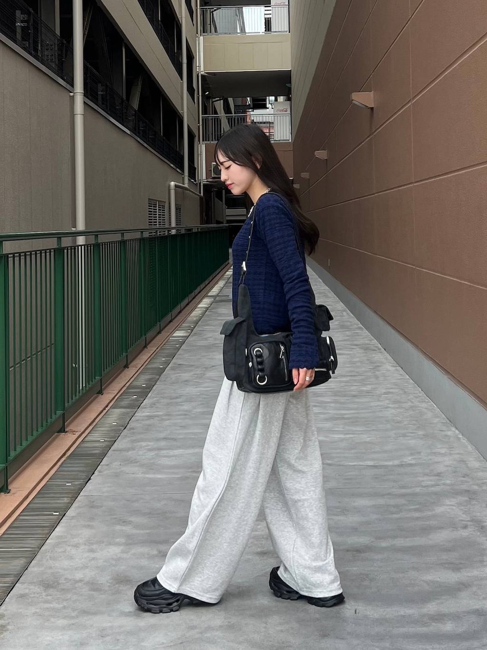 ブラック系のTシャツ/カットソー、ブラック系のショルダーバッグ、ブラック系のローファーを着用したレディースの秋コーディネートの5枚目の写真