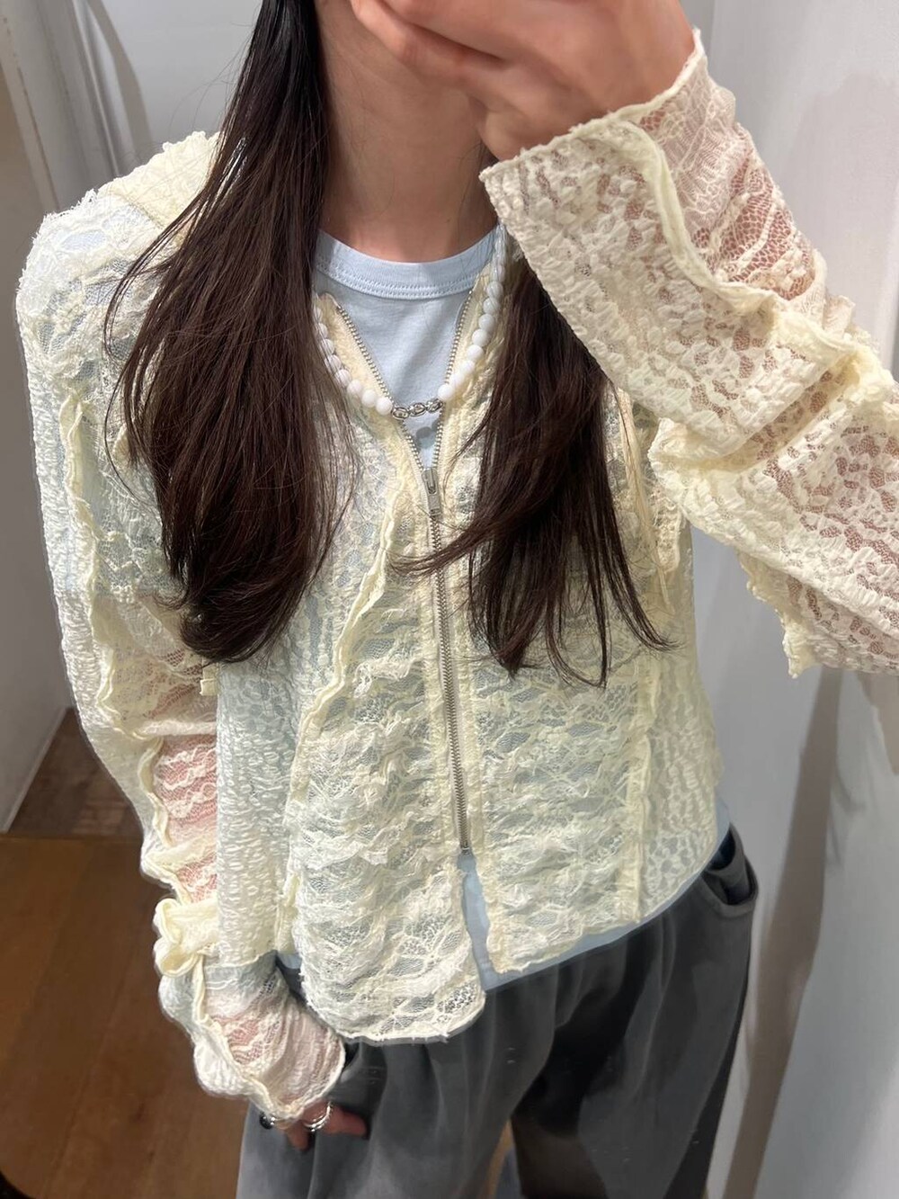 グレー系のスウェットパンツ、ホワイト系のパーカー、ブラック系のサンダルを着用したレディースの春コーディネートの2枚目の写真