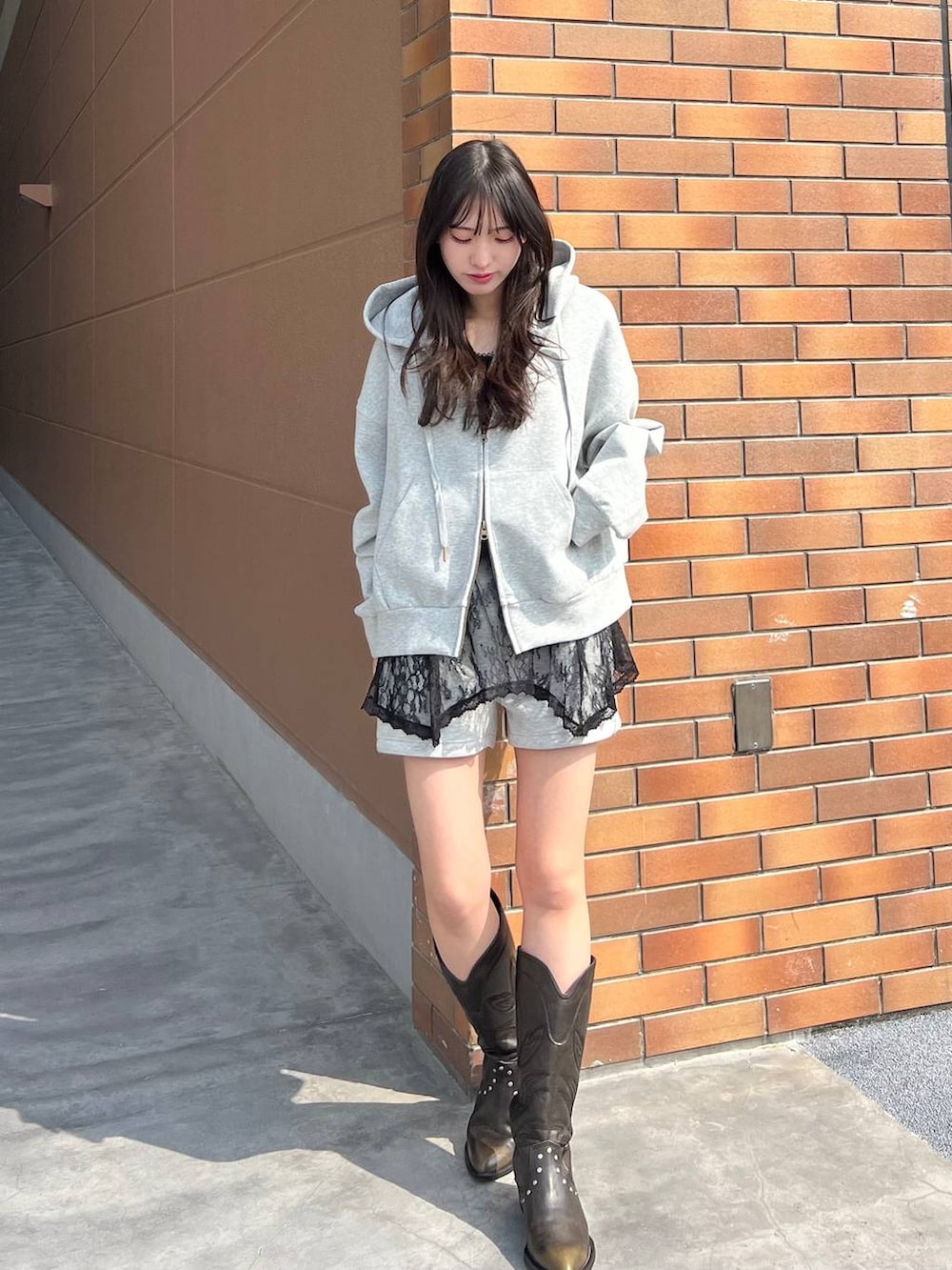 ブラック系のブーツ、グレー系のスウェットパンツ、グレー系のパーカーを着用したレディースの春コーディネートの4枚目の写真