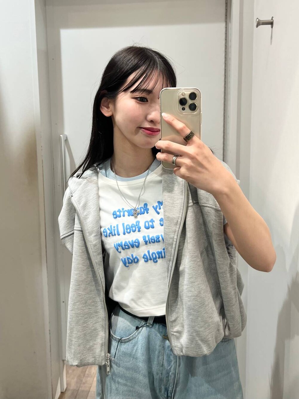 ブルー系のデニムパンツ、グレー系のベスト、ブルー系のTシャツ/カットソーを着用したレディースの春コーディネートの2枚目の写真