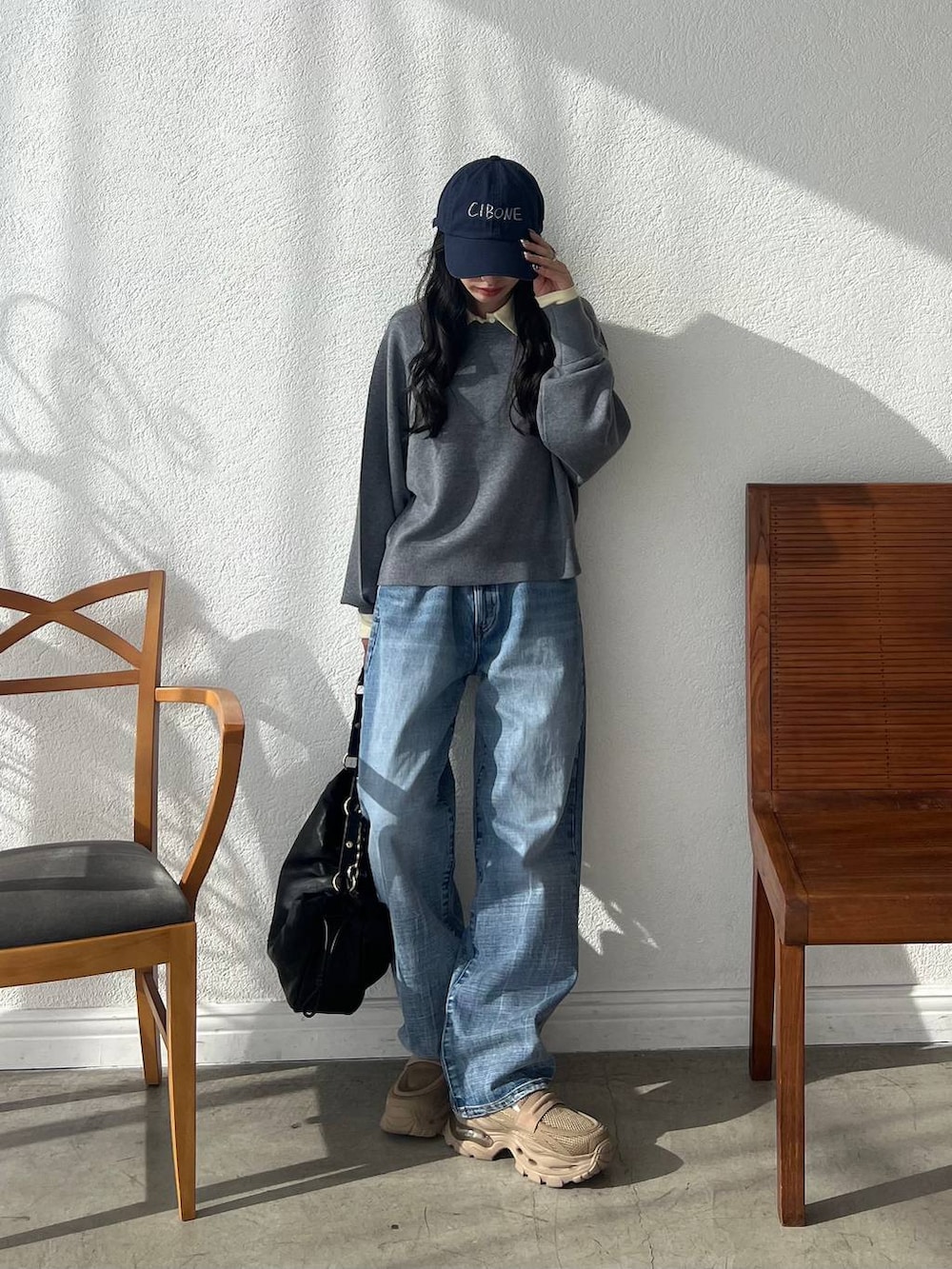 ブルー系のデニムパンツ、ブラック系のショルダーバッグ、イエロー系のポロシャツを着用したレディースの秋コーディネートの2枚目の写真