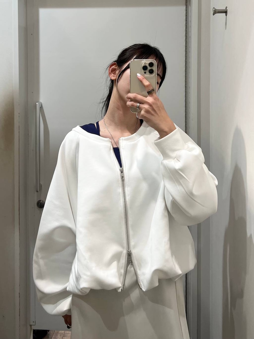 ホワイト系のスウェット、ブラック系のスニーカー、ホワイト系のスカートを着用したレディースの春コーディネートの4枚目の写真