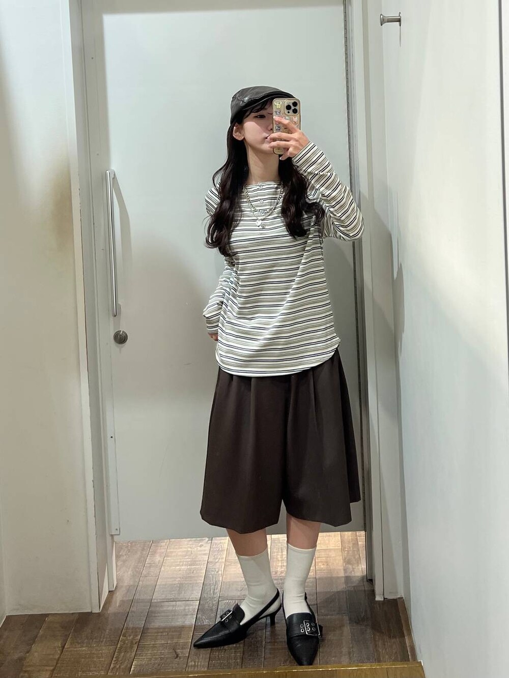 ホワイト系のTシャツ/カットソー、ブラウン系のテーラードジャケット、ブラック系のパンプスを着用したレディースの冬コーディネートの3枚目の写真