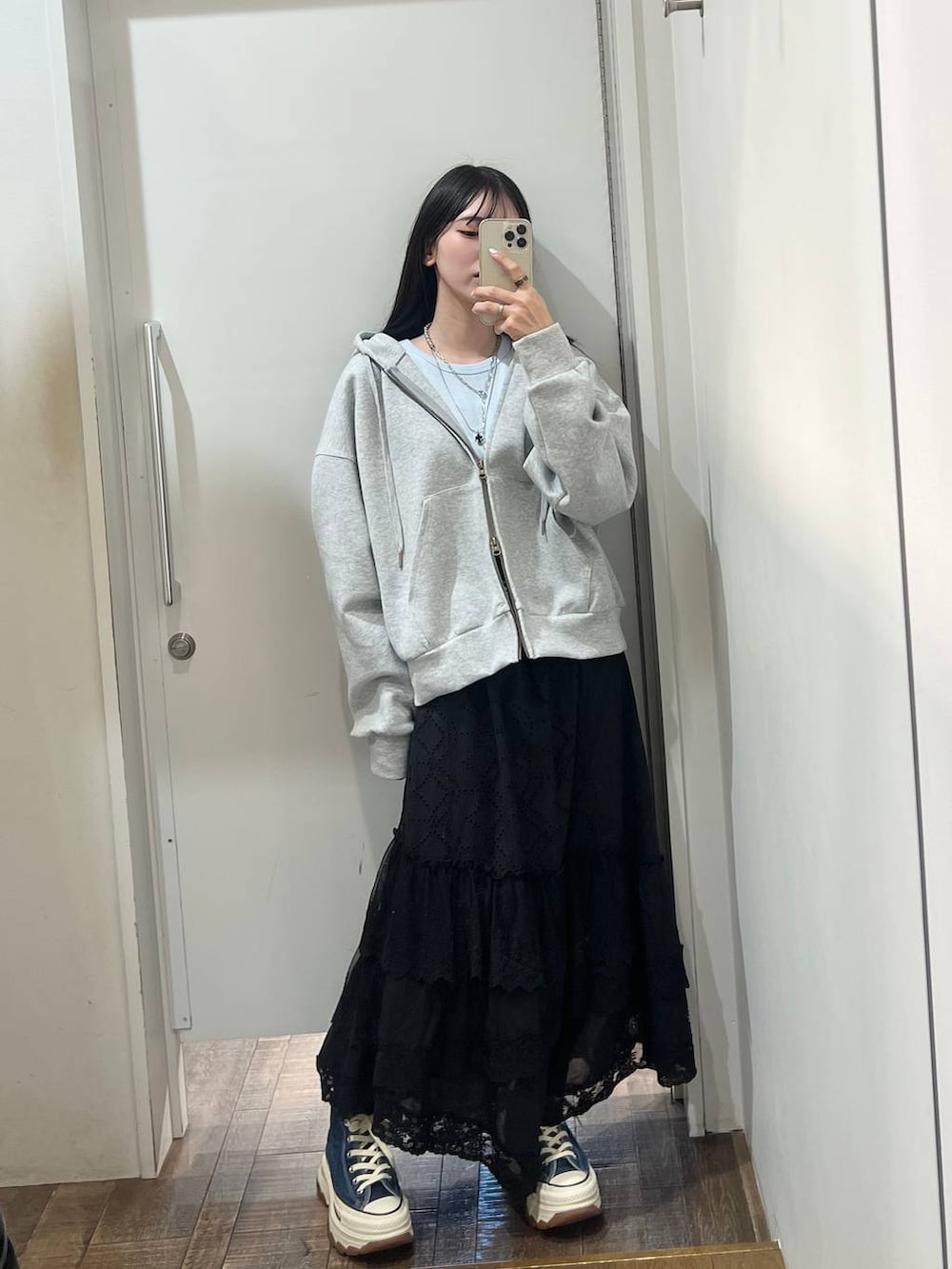 ブルー系のスニーカー、グレー系のパーカー、ブラック系のスカートを着用したレディースの春コーディネートの4枚目の写真