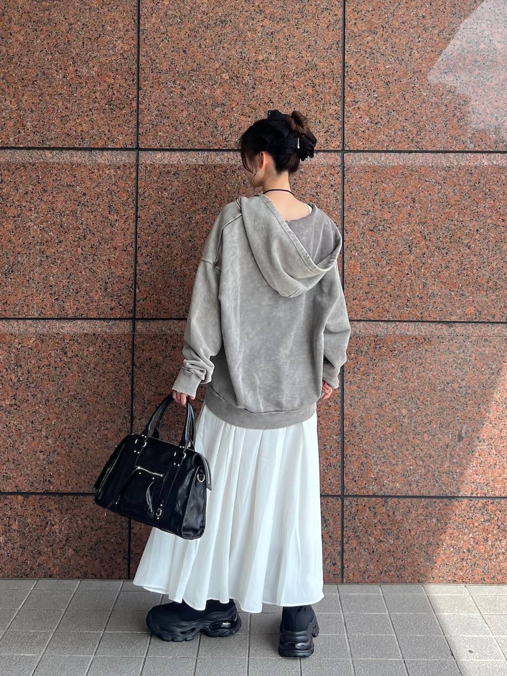 グレー系のパーカー、ブラック系のボストンバッグ、ブラック系のブーツを着用したレディースの夏コーディネートの6枚目の写真