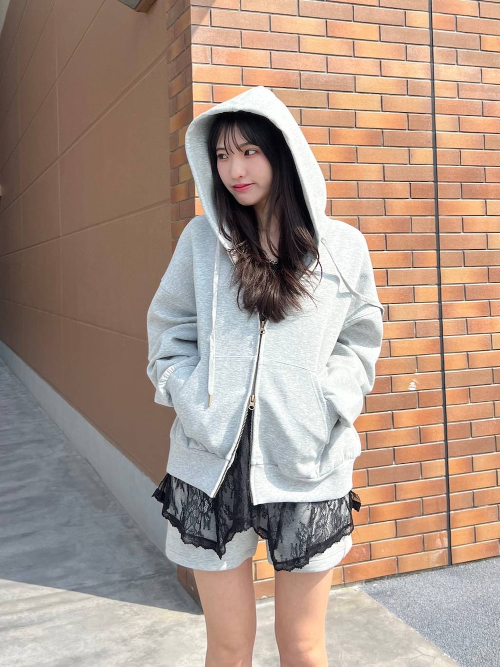 ブラック系のブーツ、グレー系のスウェットパンツ、グレー系のパーカーを着用したレディースの春コーディネートの9枚目の写真