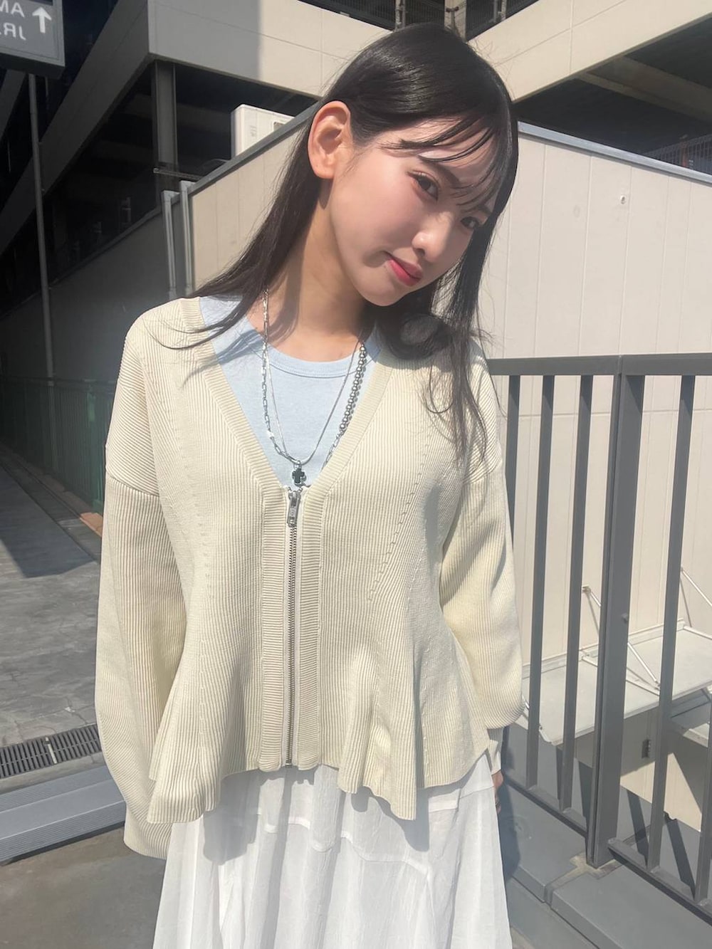 ブルー系のスニーカー、ホワイト系のカーディガン/ボレロ、ホワイト系のスカートを着用したレディースの春コーディネートの3枚目の写真