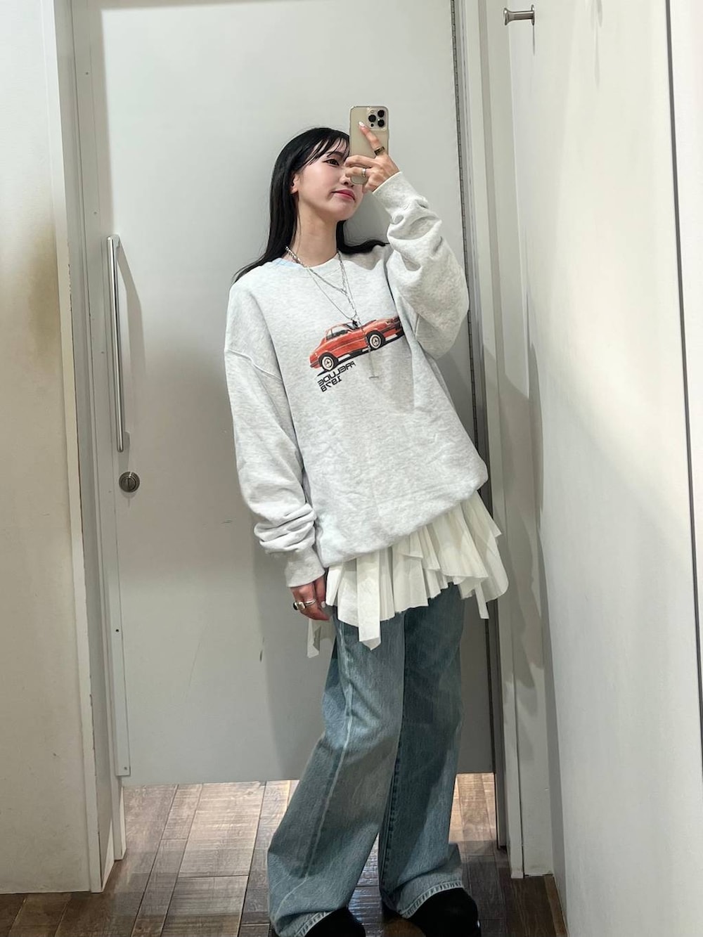 グレー系のスウェット、ブルー系のデニムパンツ、ブラック系のモカシン/デッキシューズを着用したレディースの春コーディネートの2枚目の写真