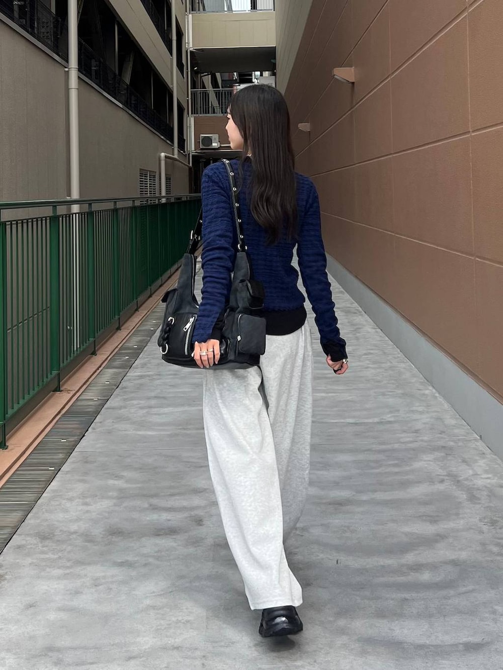 ブラック系のTシャツ/カットソー、ブラック系のショルダーバッグ、ブラック系のローファーを着用したレディースの秋コーディネートの3枚目の写真