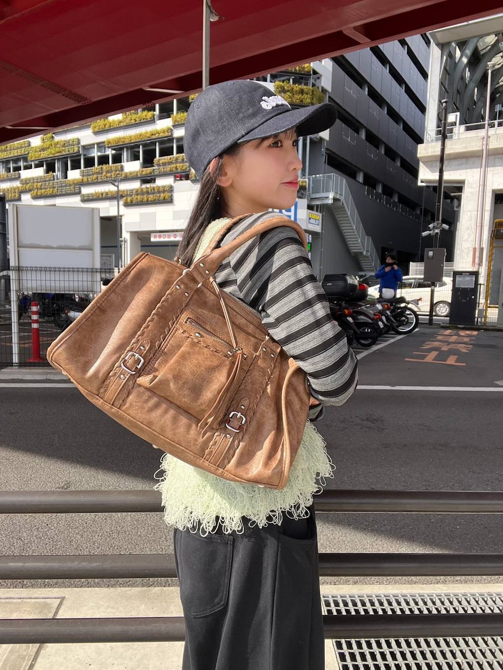 ブラック系のTシャツ/カットソー、ブラック系のスウェットパンツ、ブラウン系のボストンバッグを着用したレディースの冬コーディネートの2枚目の写真