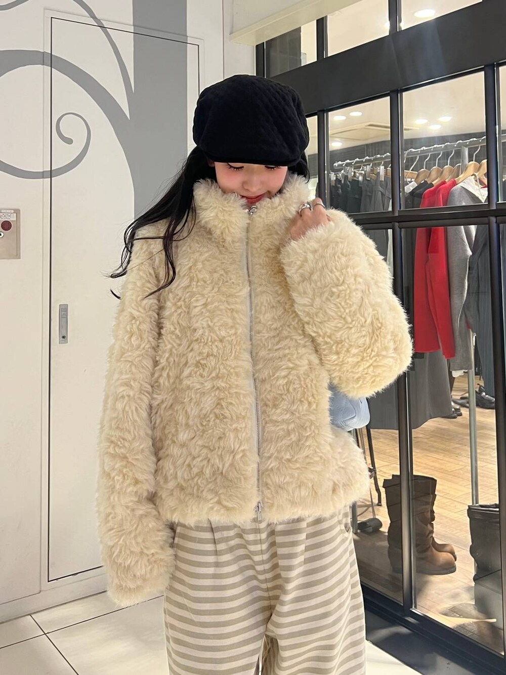 ホワイト系のブルゾン、ベージュ系のスウェットパンツ、ブルー系のショルダーバッグを着用したレディースの秋コーディネートの5枚目の写真