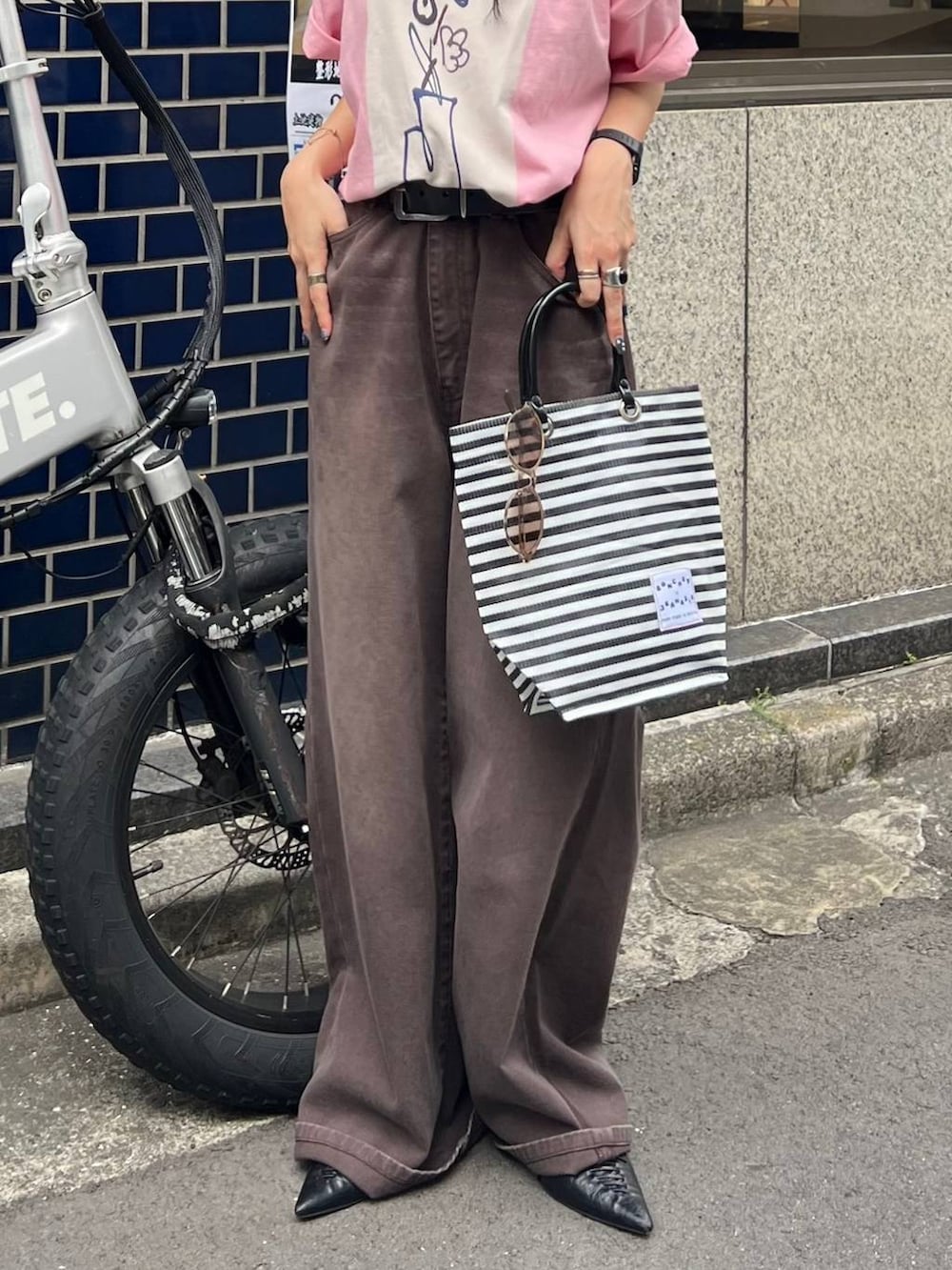 ピンク系のTシャツ/カットソー、ブラック系のパンプス、ブラウン系のデニムパンツを着用したレディースの夏コーディネートの6枚目の写真
