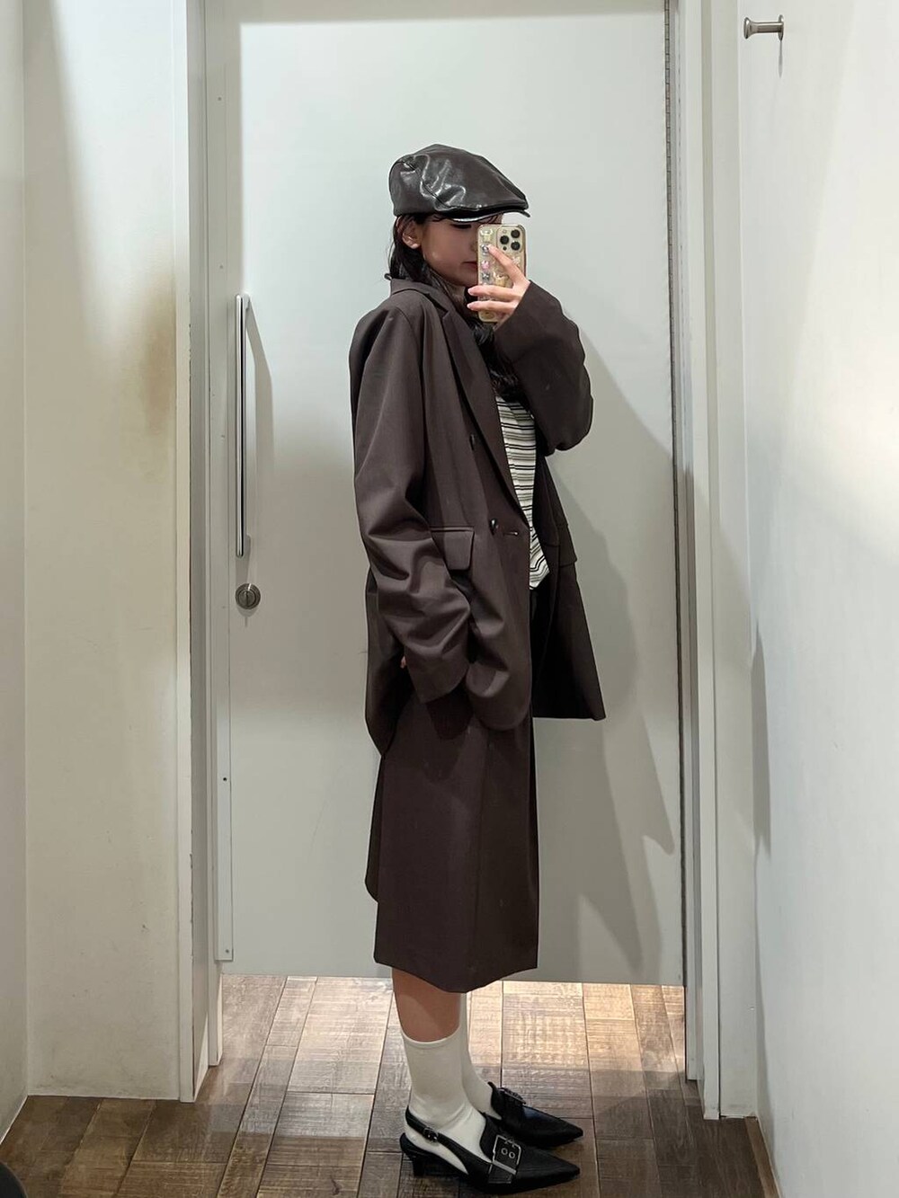 ホワイト系のTシャツ/カットソー、ブラウン系のテーラードジャケット、ブラック系のパンプスを着用したレディースの冬コーディネートの4枚目の写真