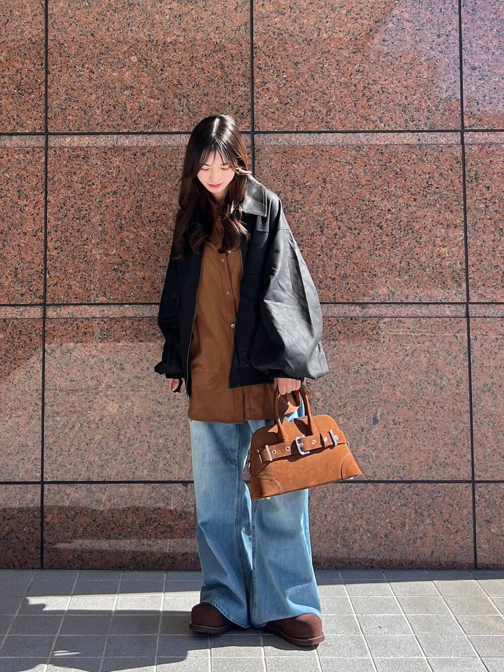 ブルー系のデニムパンツ、ブラック系のブルゾン、ブラウン系のその他シューズを着用したレディースの秋コーディネートの5枚目の写真