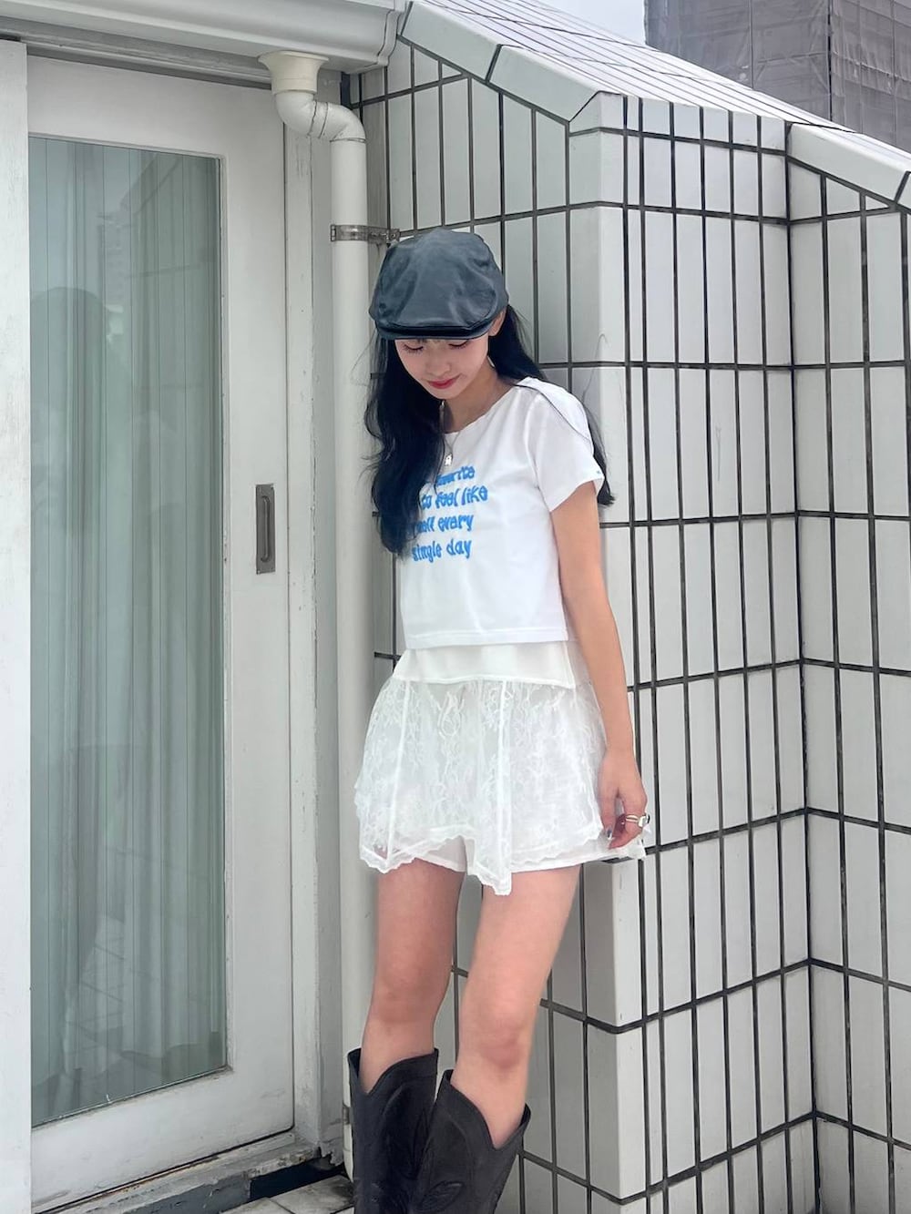 ブラック系のブーツ、ホワイト系のキャミソール、ブラック系のハンチング/ベレー帽を着用したレディースの春コーディネートの2枚目の写真