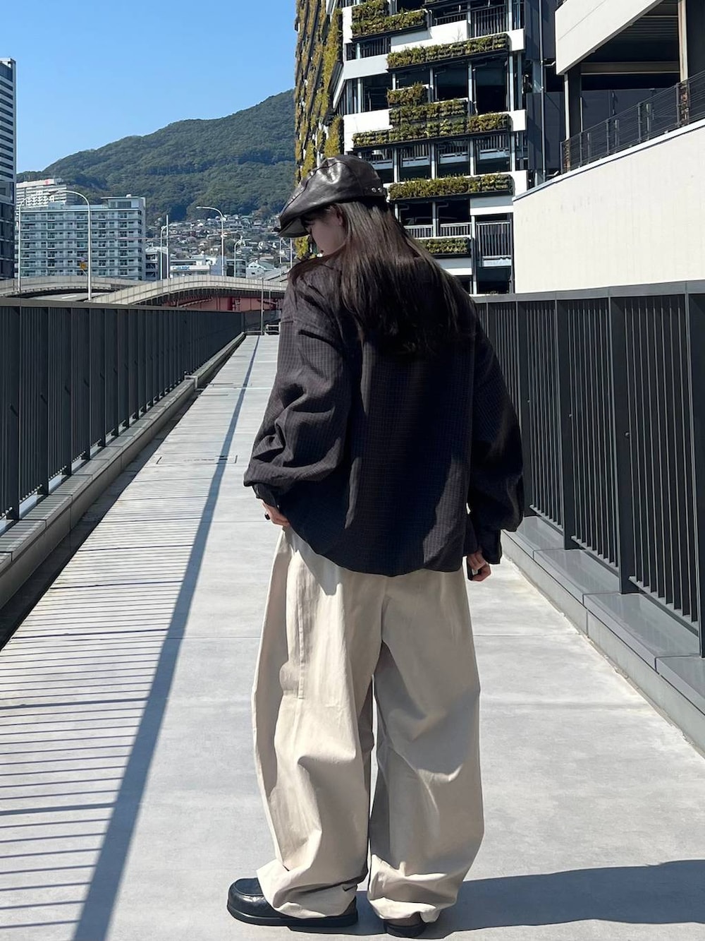 ブラック系のローファー、ブルー系のブルゾン、ブラック系のカーディガン/ボレロを着用したレディースの春コーディネートの4枚目の写真