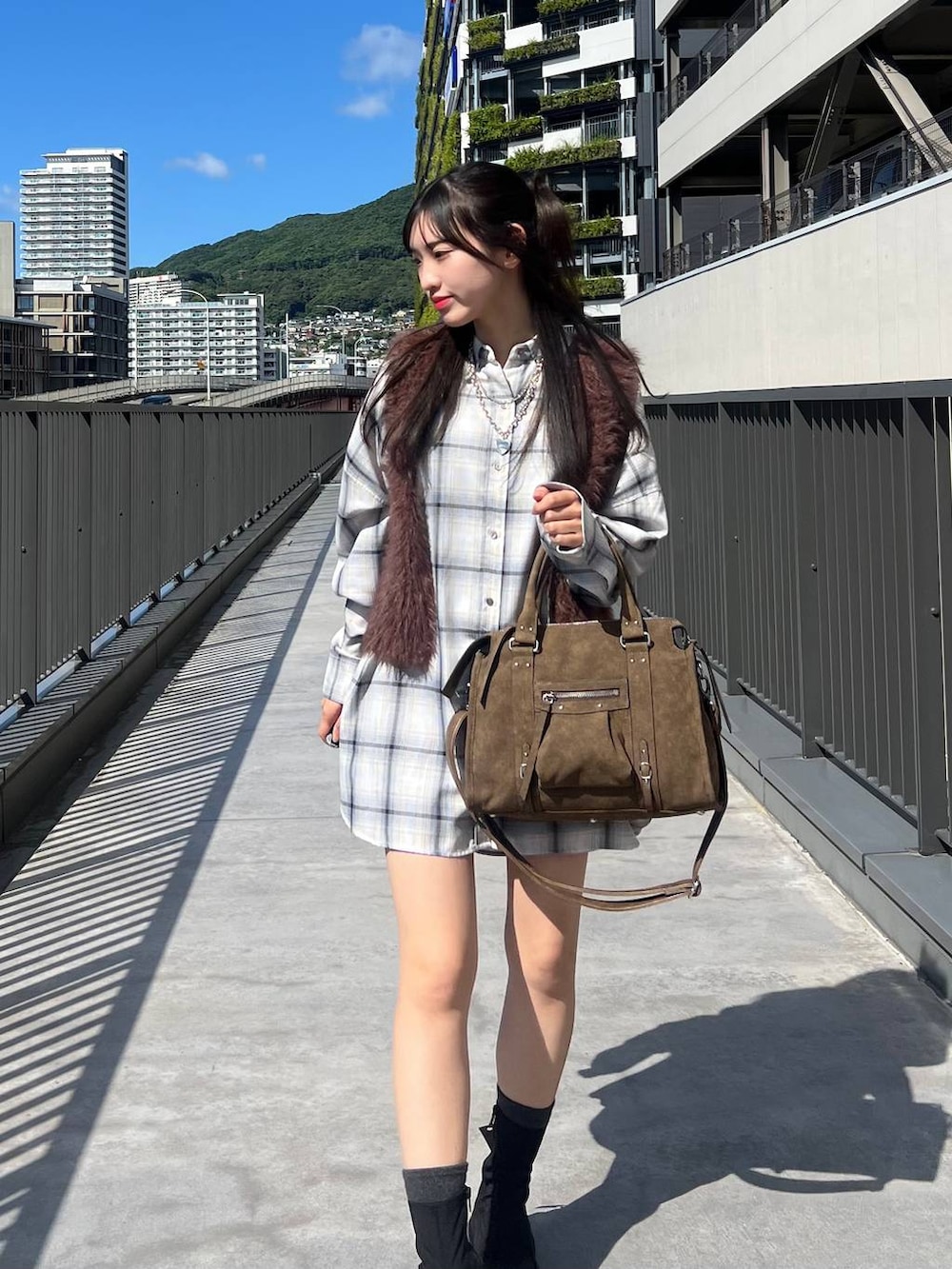 ブラウン系のベスト、ホワイト系のシャツ/ブラウス、ブラウン系のボストンバッグを着用したレディースの秋コーディネートの2枚目の写真