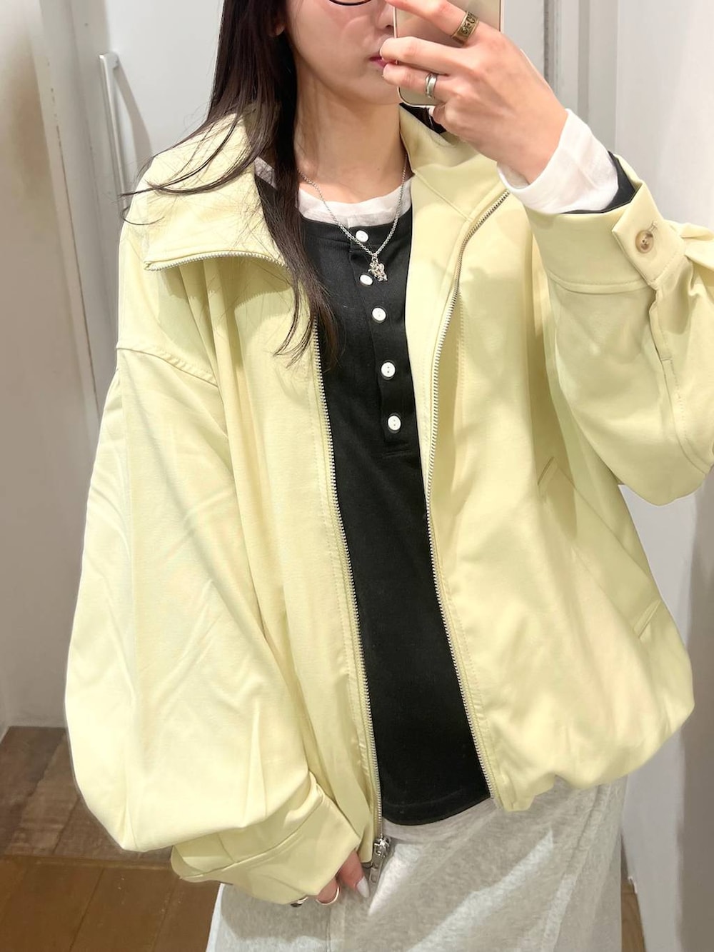 ブラック系のローファー、イエロー系のブルゾン、グレー系のスカートを着用したレディースの春コーディネートの4枚目の写真