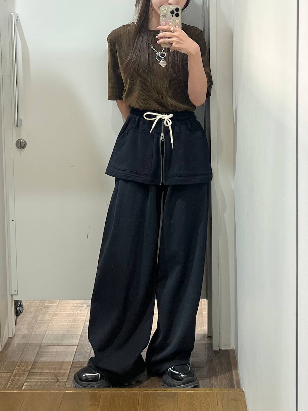 ブラック系のスニーカー、ブラック系のスウェットパンツ、ブラック系のスカートを着用したレディースの夏コーディネートの3枚目の写真