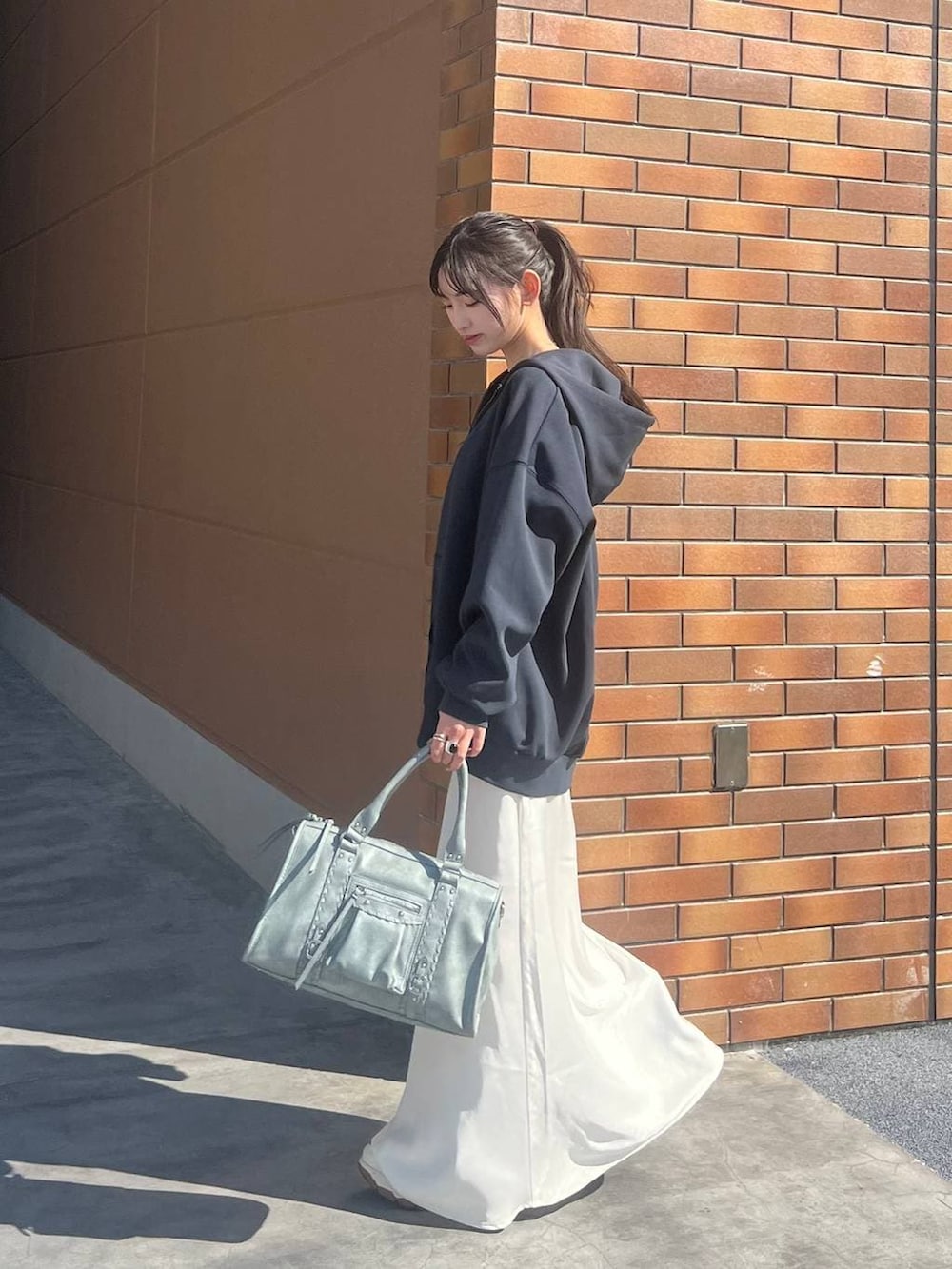 ホワイト系のTシャツ/カットソー、ブラック系のスニーカー、ホワイト系のスカートを着用したレディースの春コーディネートの3枚目の写真