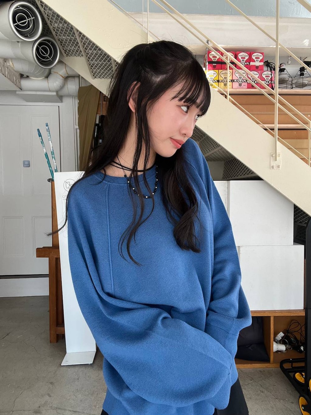 ブラック系のその他パンツ、ブラック系のショルダーバッグ、ブルー系のニット/セーターを着用したレディースの秋コーディネートの6枚目の写真