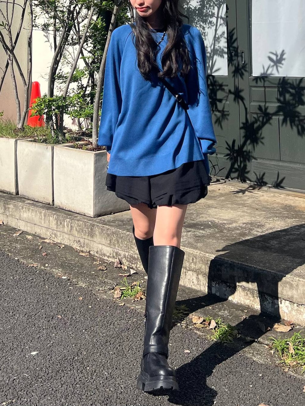 ブラック系のその他パンツ、ブラック系のショルダーバッグ、ブルー系のニット/セーターを着用したレディースの秋コーディネートの2枚目の写真