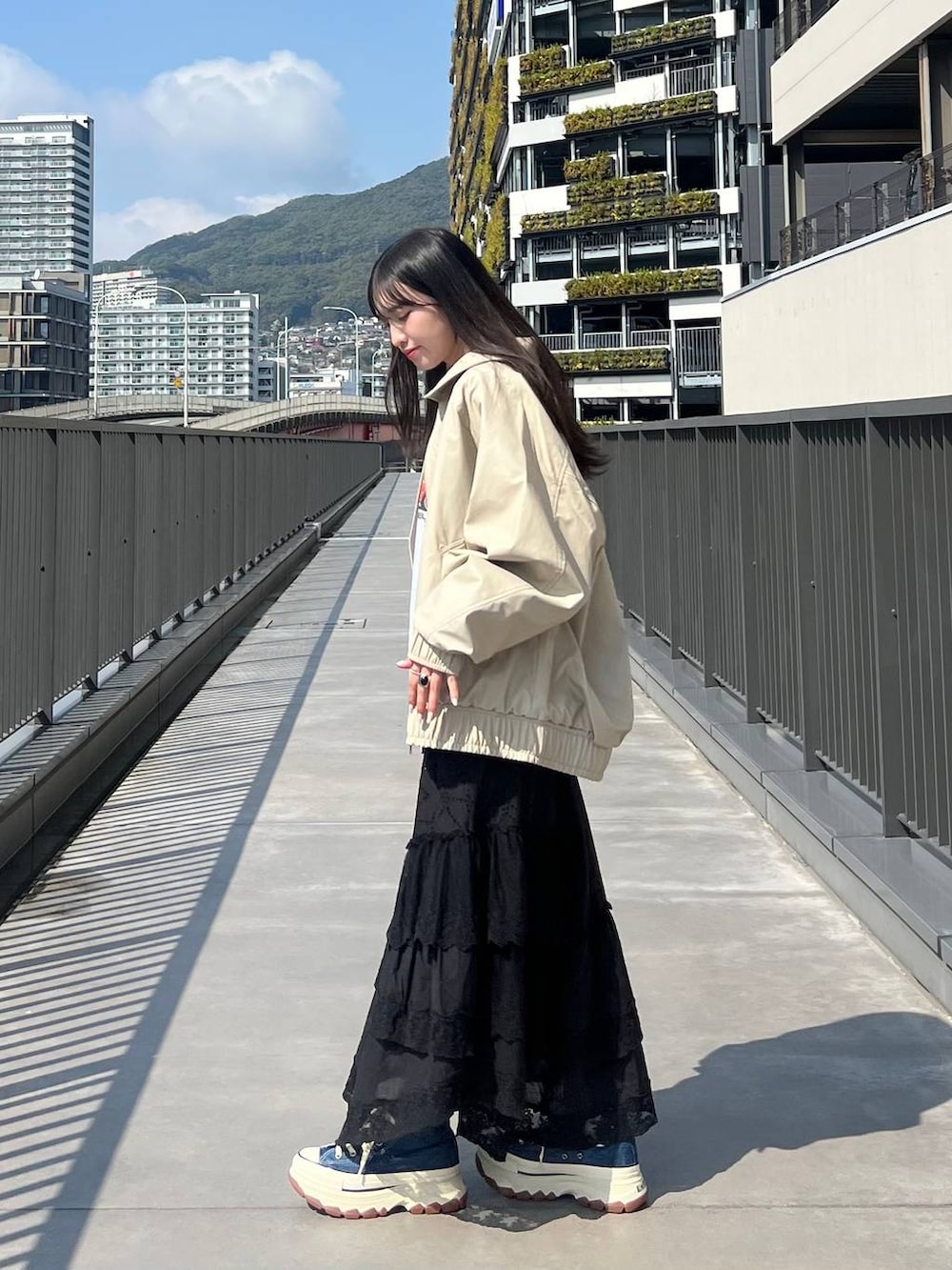 ブルー系のスニーカー、グレー系のスウェット、ベージュ系のブルゾンを着用したレディースの春コーディネートの4枚目の写真