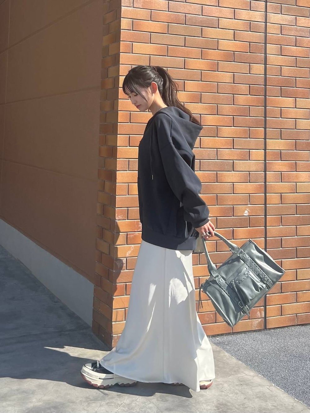 ホワイト系のTシャツ/カットソー、ブラック系のスニーカー、ホワイト系のスカートを着用したレディースの春コーディネートの8枚目の写真