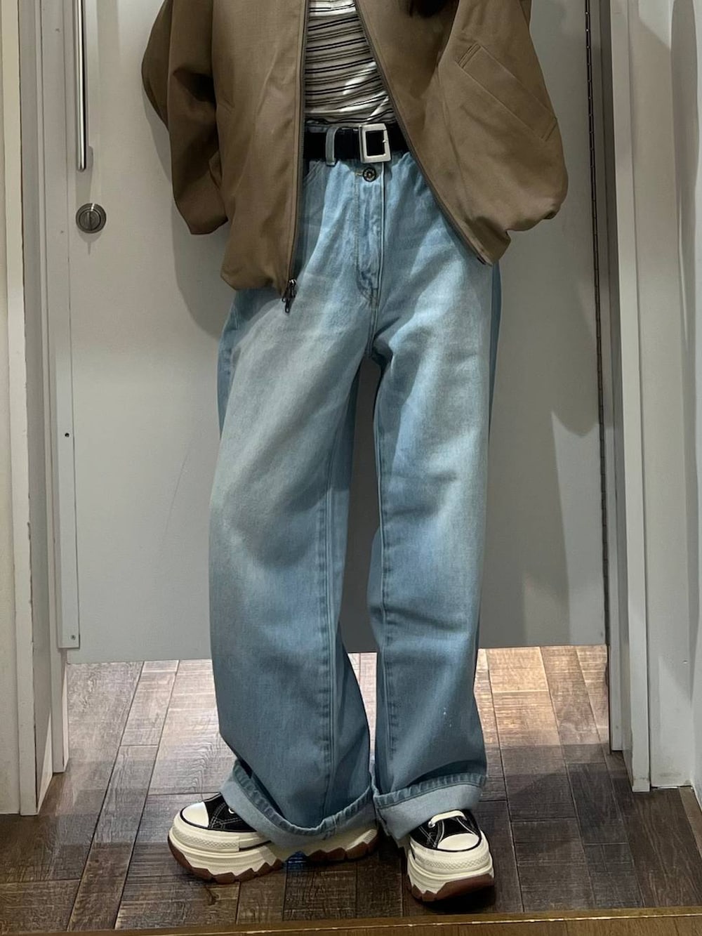 ホワイト系のTシャツ/カットソー、ブラック系のスニーカー、ブルー系のデニムパンツを着用したレディースの冬コーディネートの2枚目の写真