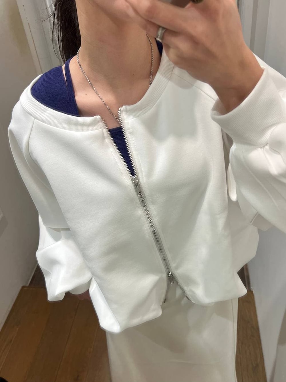 ホワイト系のスウェット、ブラック系のスニーカー、ホワイト系のスカートを着用したレディースの春コーディネートの2枚目の写真