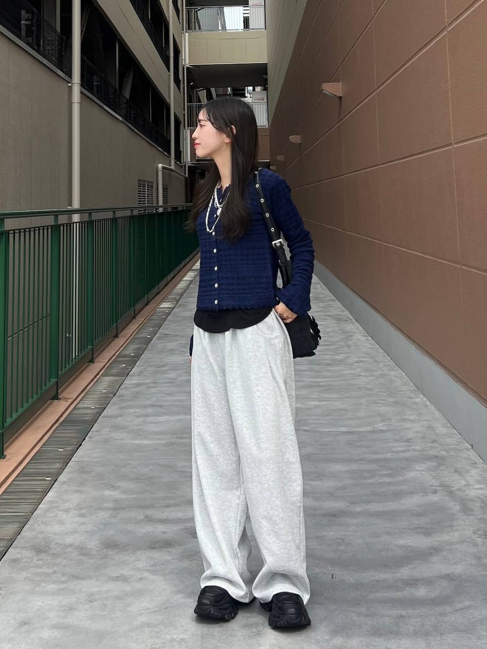 ブラック系のTシャツ/カットソー、ブラック系のショルダーバッグ、ブラック系のローファーを着用したレディースの秋コーディネートの4枚目の写真