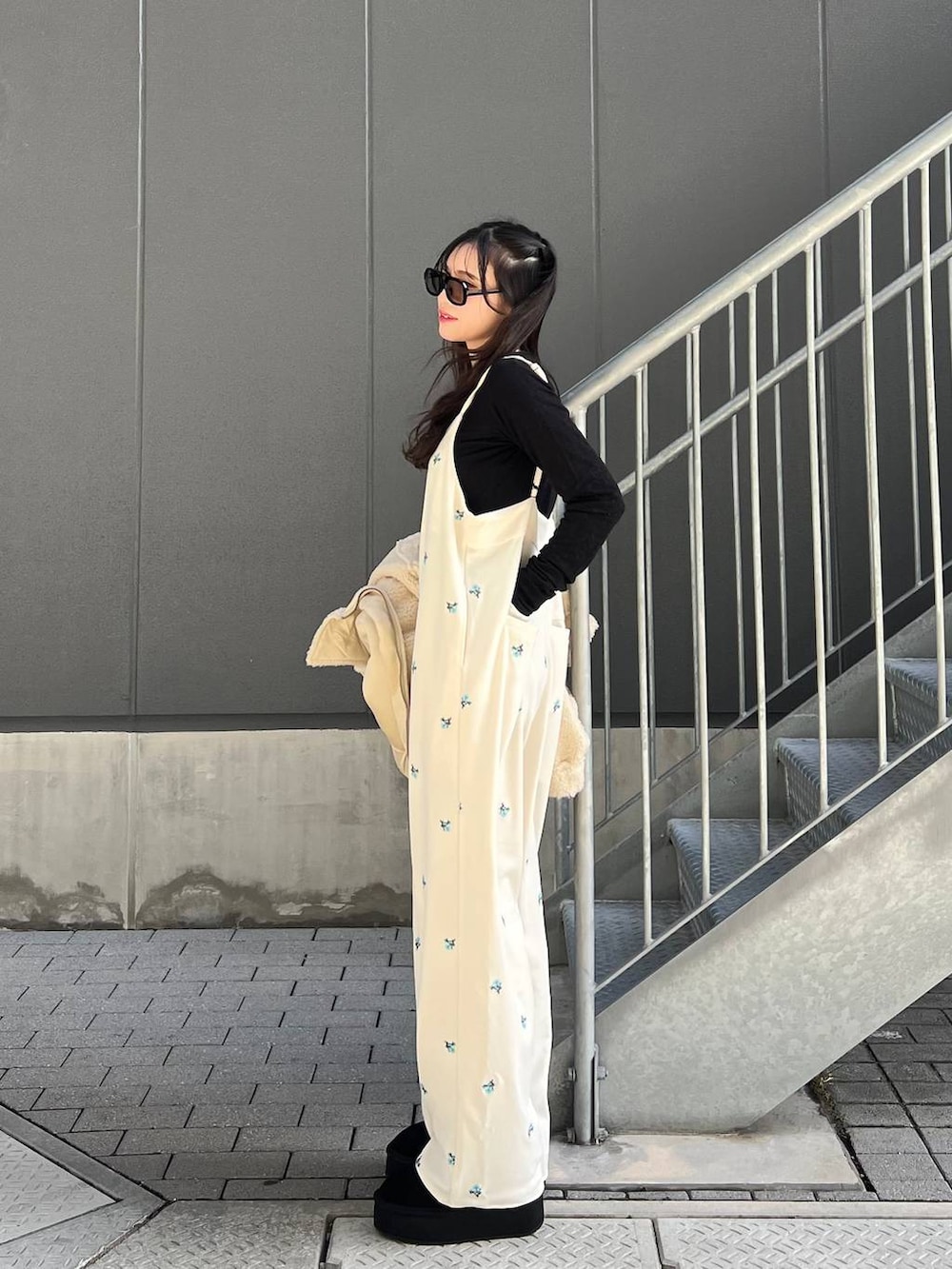 ブラック系のブーツ、ホワイト系のブルゾン、ブラック系のTシャツ/カットソーを着用したレディースの冬コーディネートの2枚目の写真