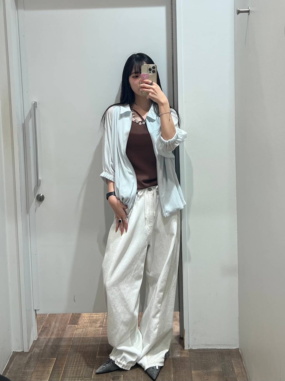 ホワイト系のデニムパンツ、ブラウン系のタンクトップ、ブラック系のパンプスを着用したレディースの夏コーディネートの5枚目の写真