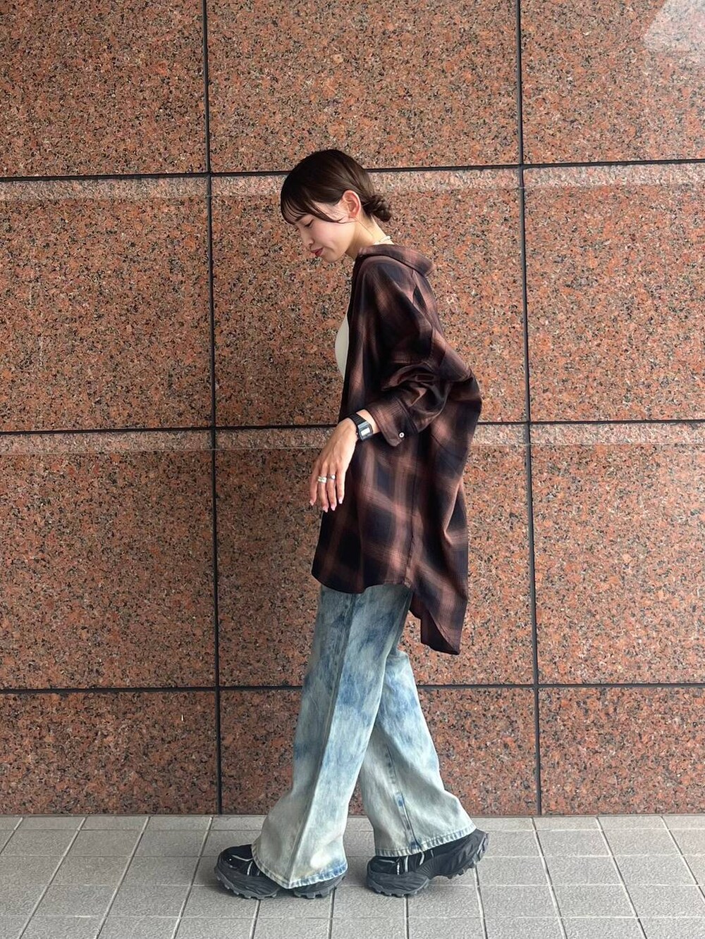 ブラウン系のシャツ/ブラウス、ブラック系のスニーカー、ブルー系のデニムパンツを着用したレディースの夏コーディネートの3枚目の写真