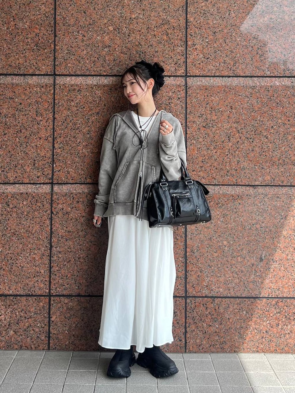 グレー系のパーカー、ブラック系のボストンバッグ、ブラック系のブーツを着用したレディースの夏コーディネートの8枚目の写真