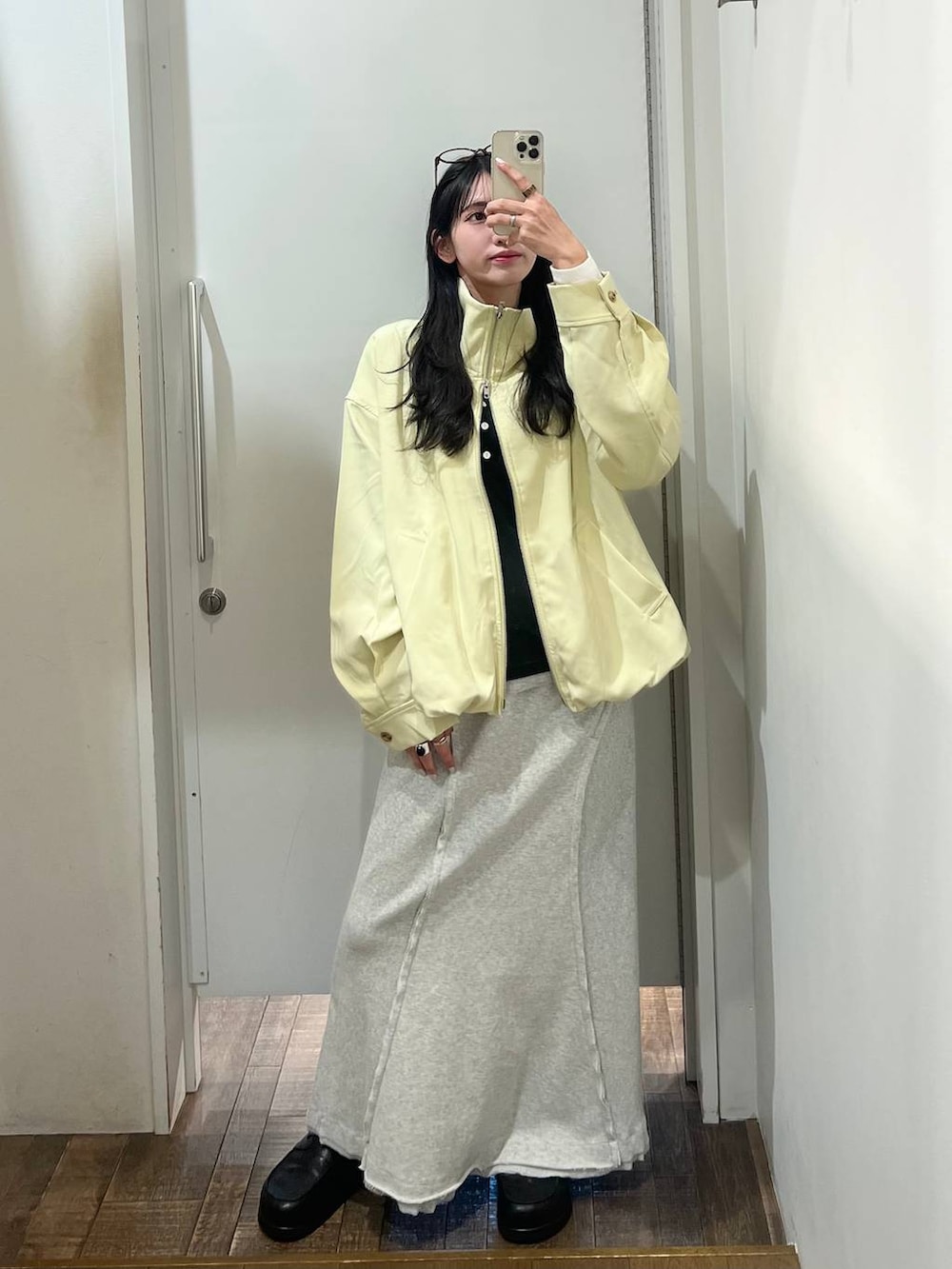 ブラック系のローファー、イエロー系のブルゾン、グレー系のスカートを着用したレディースの春コーディネートの3枚目の写真
