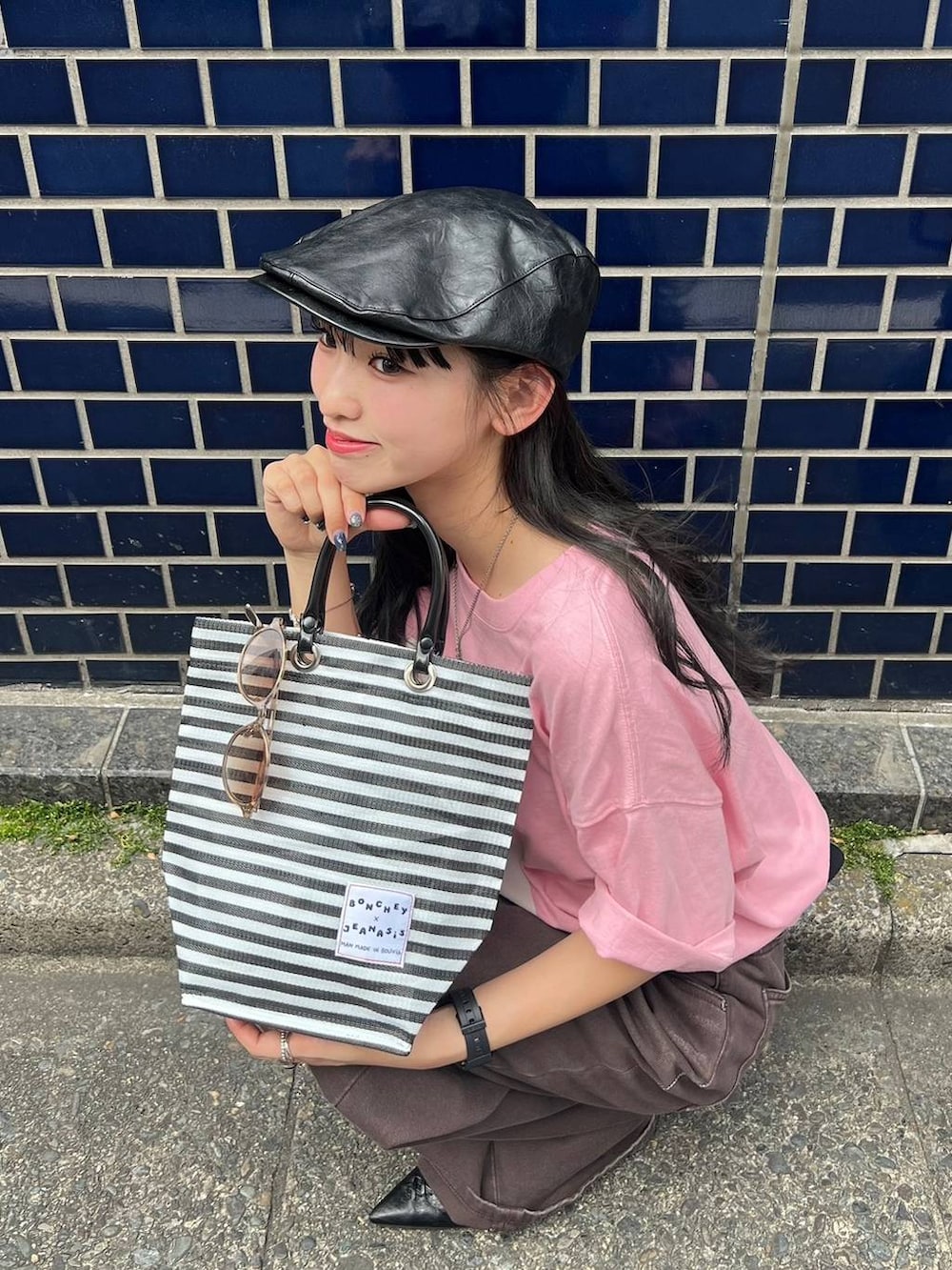 ピンク系のTシャツ/カットソー、ブラック系のパンプス、ブラウン系のデニムパンツを着用したレディースの夏コーディネートの3枚目の写真