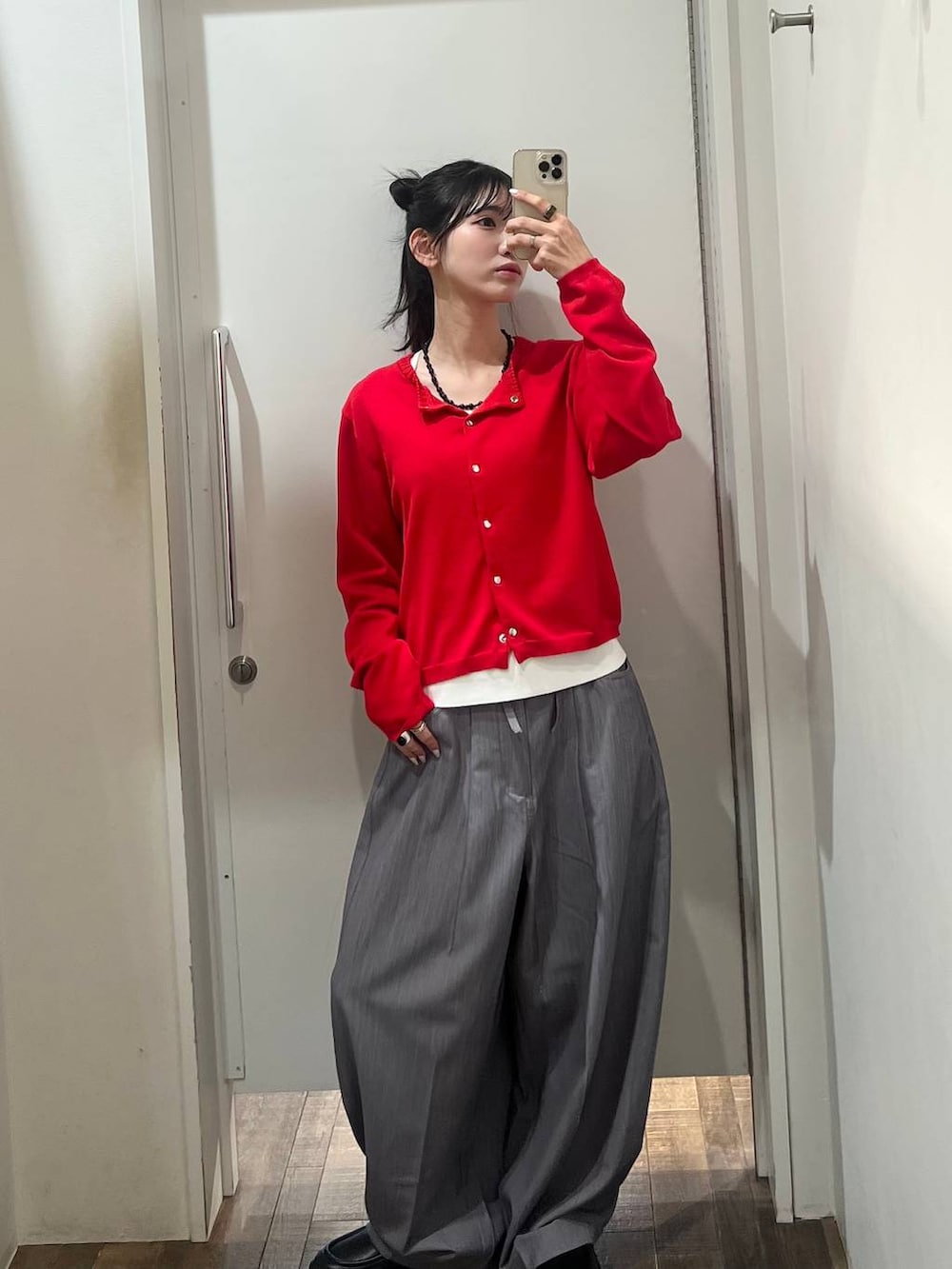 ブラック系のローファー、グレー系のスラックス、レッド系のカーディガン/ボレロを着用したレディースの春コーディネートの3枚目の写真