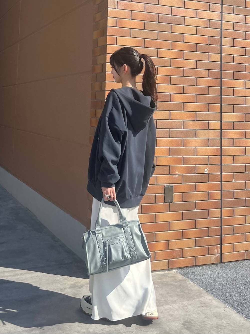 ホワイト系のTシャツ/カットソー、ブラック系のスニーカー、ホワイト系のスカートを着用したレディースの春コーディネートの5枚目の写真