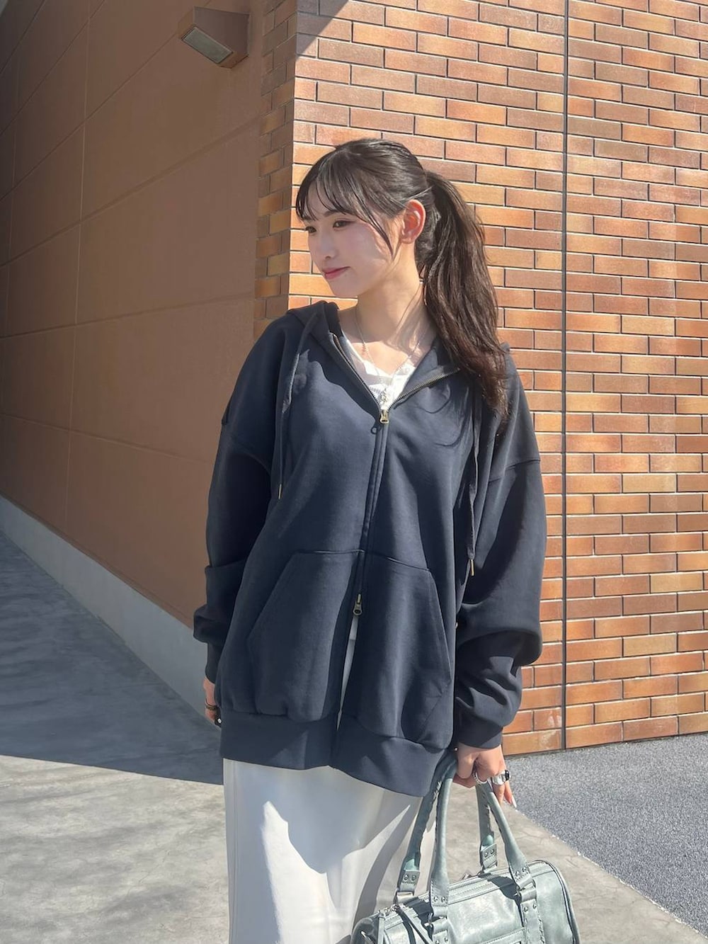 ホワイト系のTシャツ/カットソー、ブラック系のスニーカー、ホワイト系のスカートを着用したレディースの春コーディネートの4枚目の写真